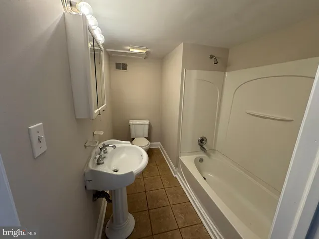 a bathroom with a bathtub a sink and a mirror