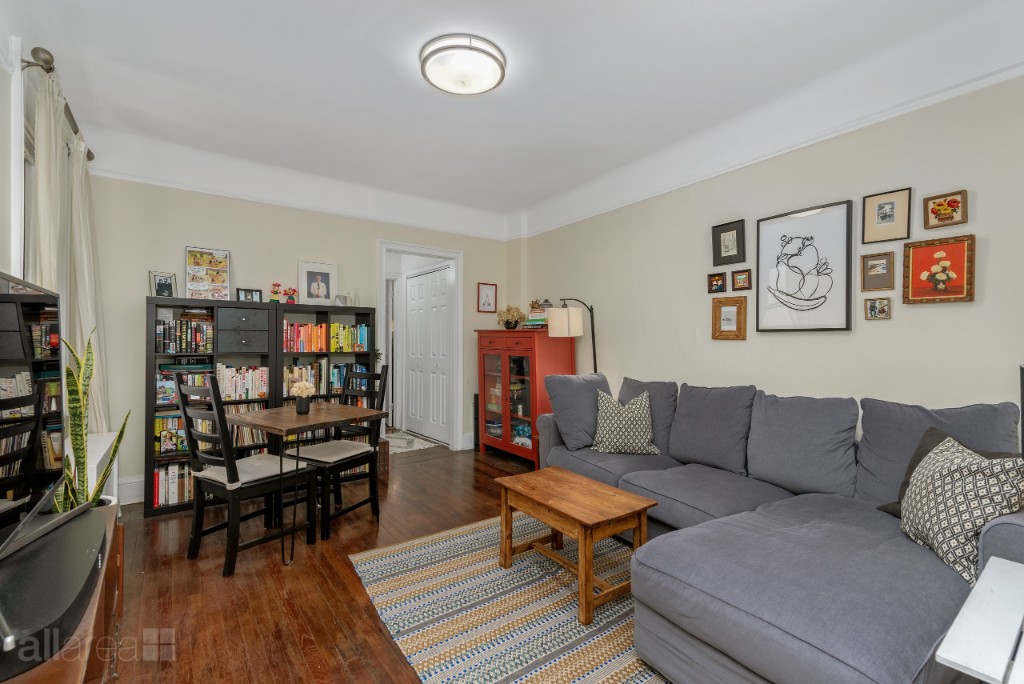 a living room with furniture a rug and a bookshelf