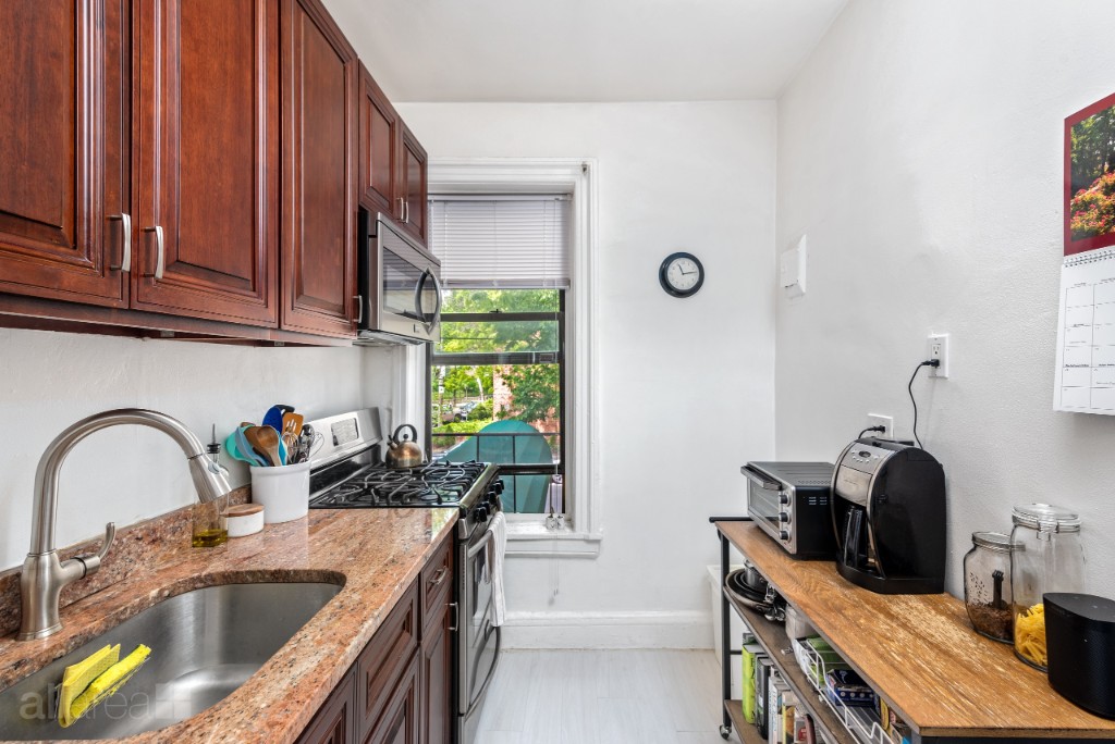 39-75 56th Street, Unit 2A Queens, NY 11377 - Photo 4 of 12 a kitchen with a sink stove and cabinets