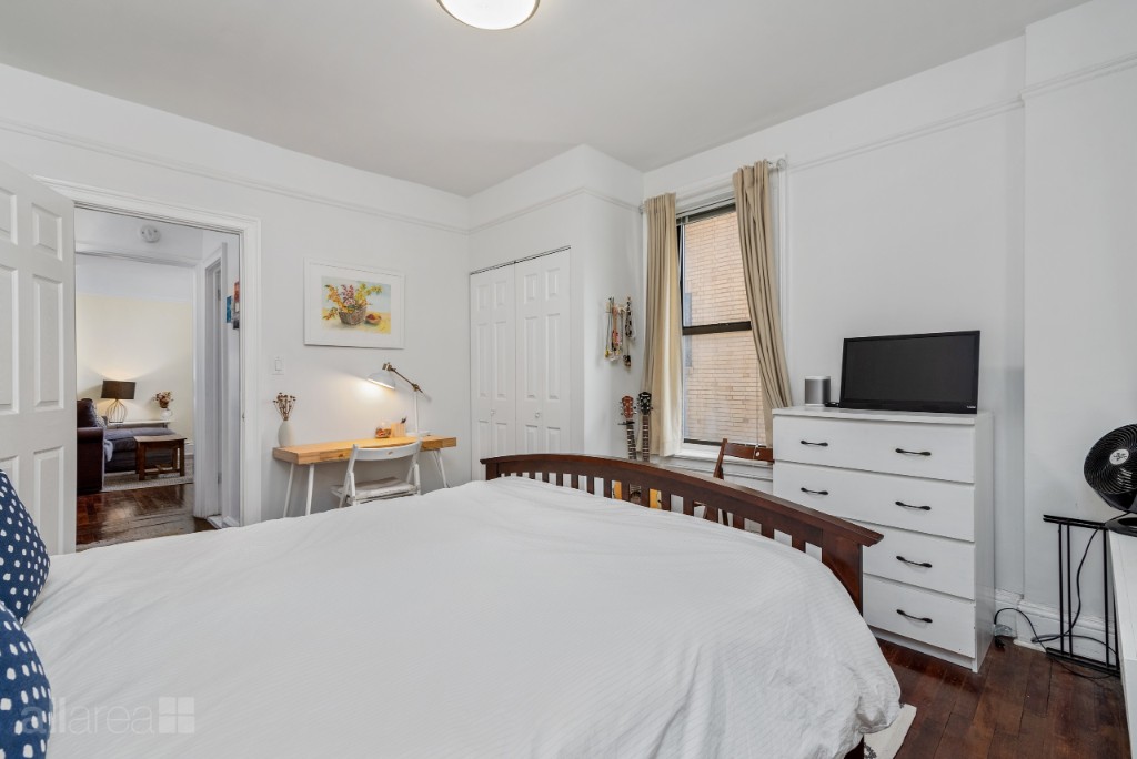 39-75 56th Street, Unit 2A Queens, NY 11377 - Photo 5 of 12 a bedroom with a bed and a flat screen tv
