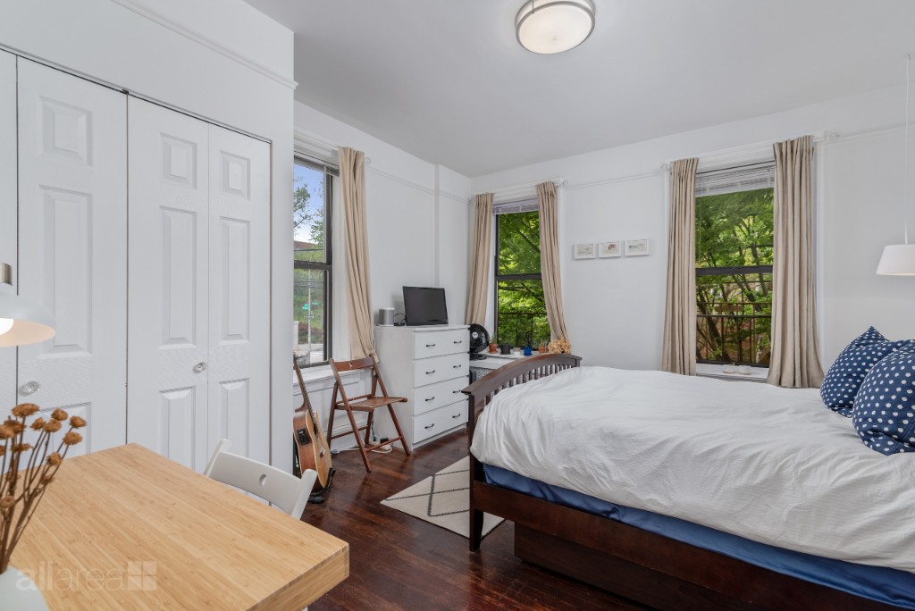 39-75 56th Street, Unit 2A Queens, NY 11377 - Photo 6 of 12 a bedroom with a bed and wooden floor