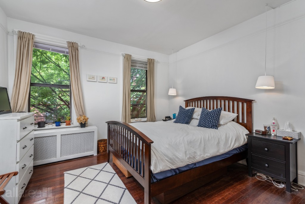 39-75 56th Street, Unit 2A Queens, NY 11377 - Photo 9 of 12 a bedroom with a bed and a window