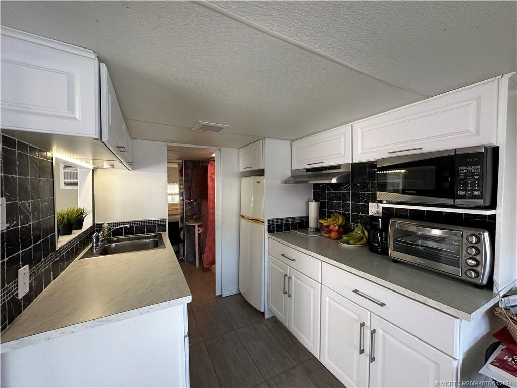 10725 South Ocean Drive, Unit 68 Jensen Beach, FL 34957 - Photo 12 of 27 a kitchen with a sink and stainless steel appliances