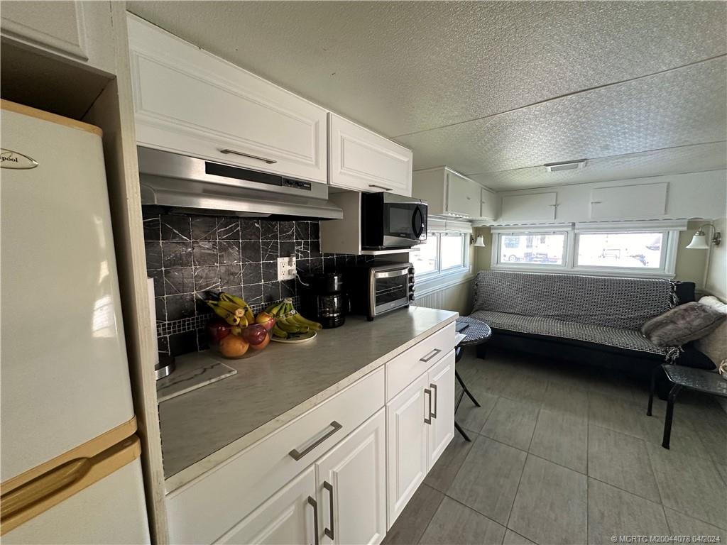 10725 South Ocean Drive, Unit 68 Jensen Beach, FL 34957 - Photo 14 of 27 a kitchen with refrigerator and window