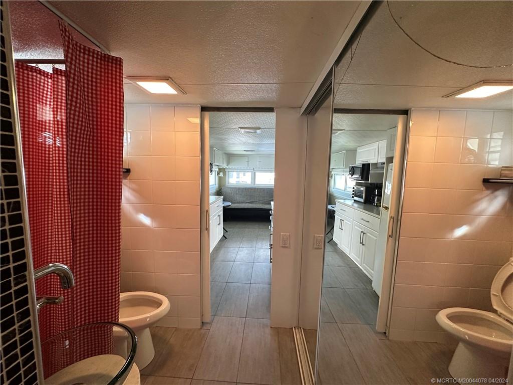 10725 South Ocean Drive, Unit 68 Jensen Beach, FL 34957 - Photo 19 of 27 a bathroom with a toilet and a shower