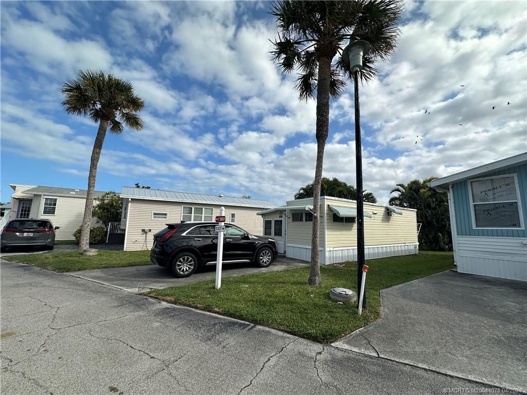 10725 South Ocean Drive, Unit 68 Jensen Beach, FL 34957 - Photo 3 of 27 a car parked in front of a house and a yard