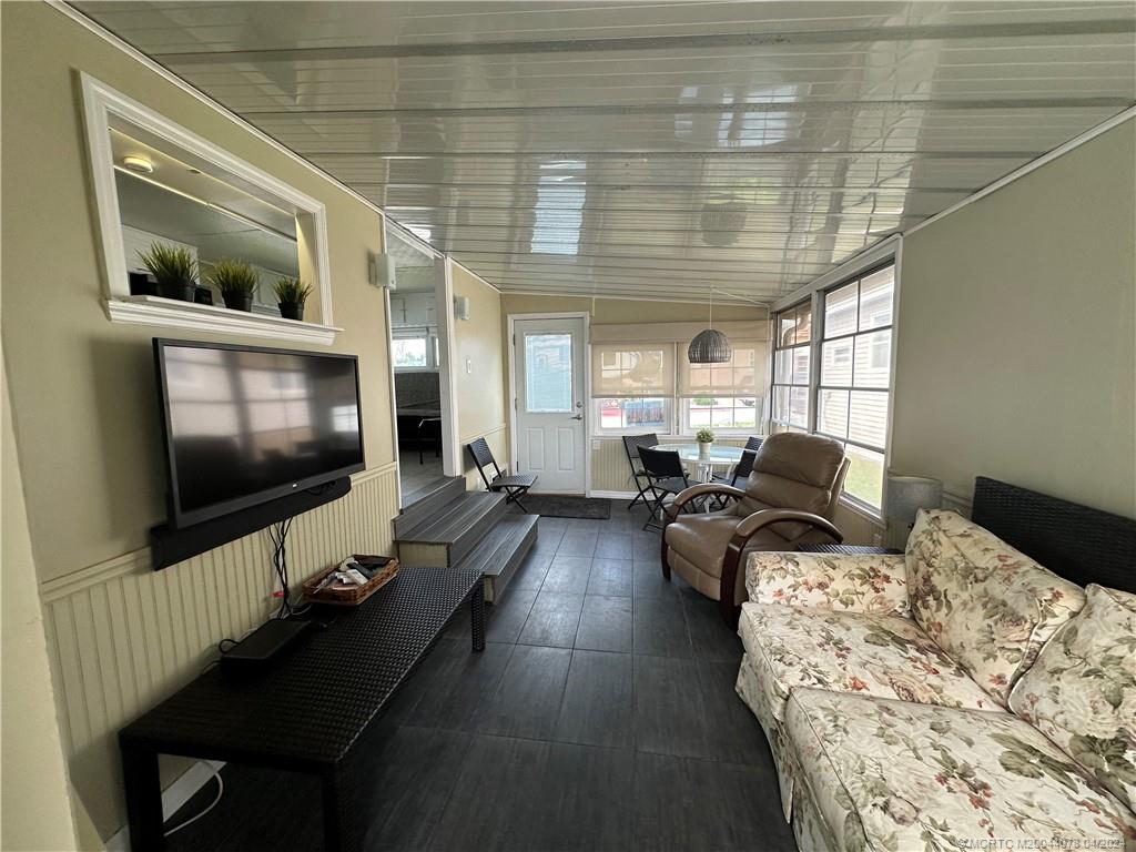 10725 South Ocean Drive, Unit 68 Jensen Beach, FL 34957 - Photo 8 of 27 a living room with furniture and a flat screen tv