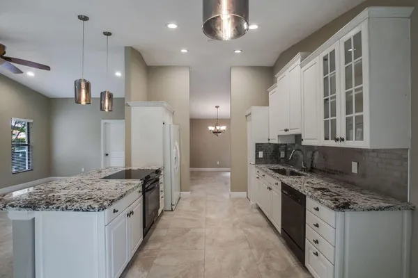a large kitchen with stainless steel appliances granite countertop a stove and a sink