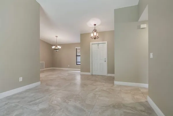 en empty room with windows and chandelier fan