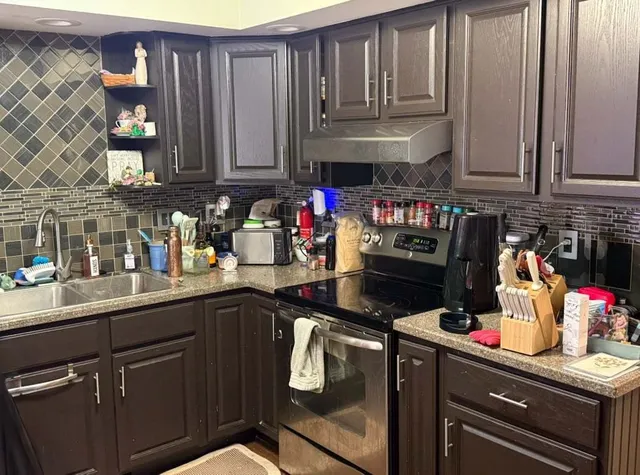 a kitchen with stainless steel appliances granite countertop a sink dishwasher stove and cabinets
