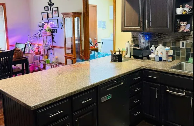 a kitchen with stainless steel appliances a sink dishwasher and cabinets with wooden floor