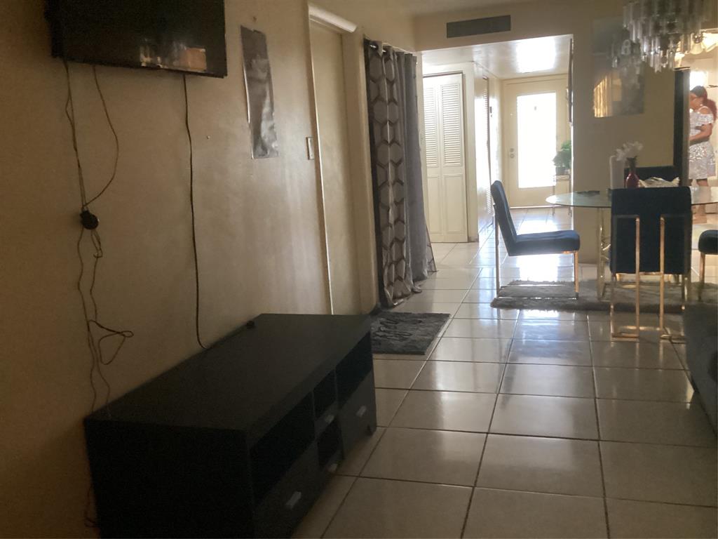 3161 Northwest 47th Terrace, Unit 317 Lauderdale Lakes, FL 33319 - Photo 17 of 20 a living room with a table and a refrigerator