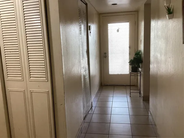 a view of a hallway with windows and closet