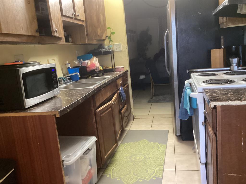 3161 Northwest 47th Terrace, Unit 317 Lauderdale Lakes, FL 33319 - Photo 7 of 20 a kitchen with a sink stove and cabinets