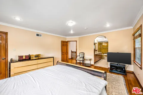 a spacious bedroom with a bed and glass windows