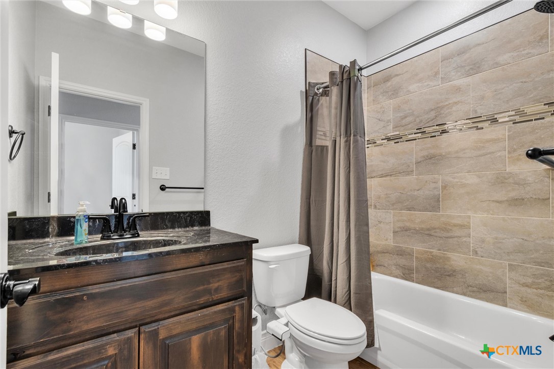 3919 Gracey Lane Kempner, TX 76539 - Photo 30 of 44 a bathroom with a granite countertop sink toilet and shower