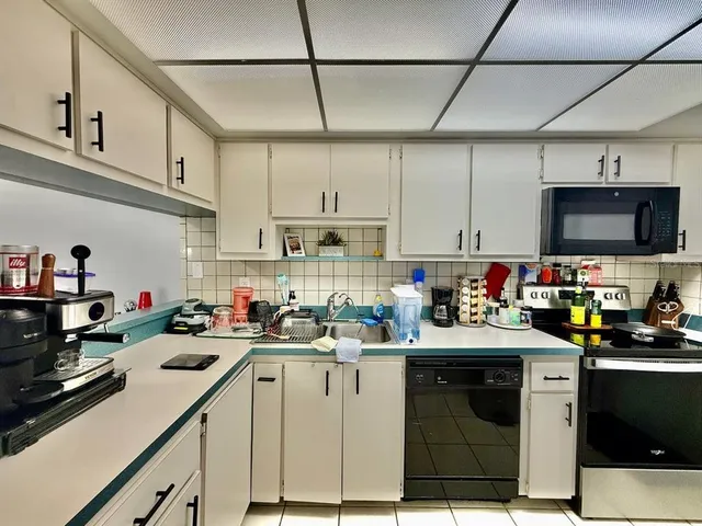 a kitchen with sink a microwave and cabinets