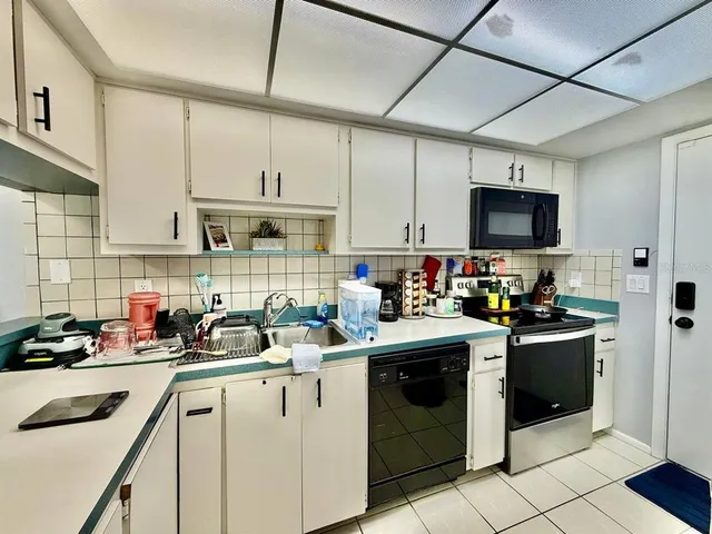 a kitchen with stainless steel appliances a stove sink microwave and cabinets