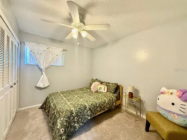 a bedroom with a bed and a chandelier fan