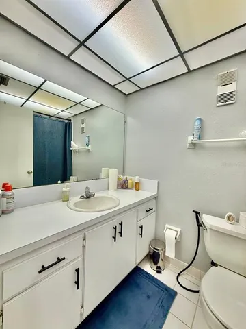 a bathroom with a granite countertop toilet sink and mirror