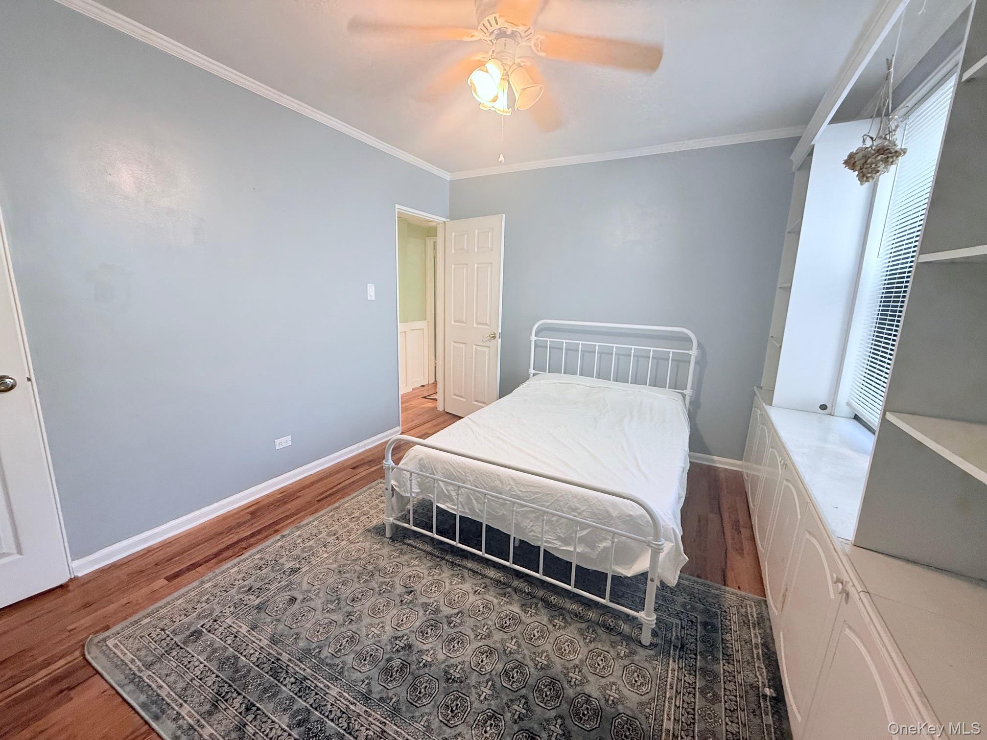 83-30 98th Street, Unit 6M Queens, NY 11421 - Photo 8 of 10 a bedroom with a bed and a chandelier