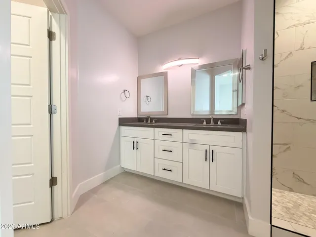 a spacious bathroom with a granite countertop sink and a mirror