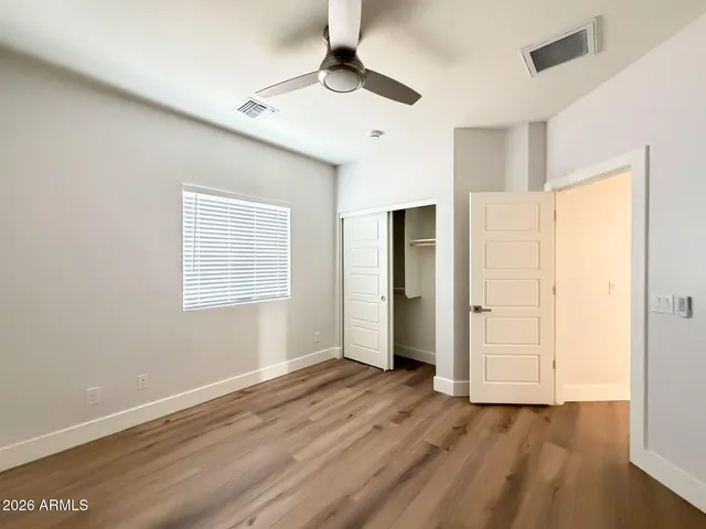 a view of an empty room with window and wooden floor