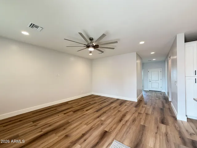 a view of a room with wooden floor and a ceiling fan