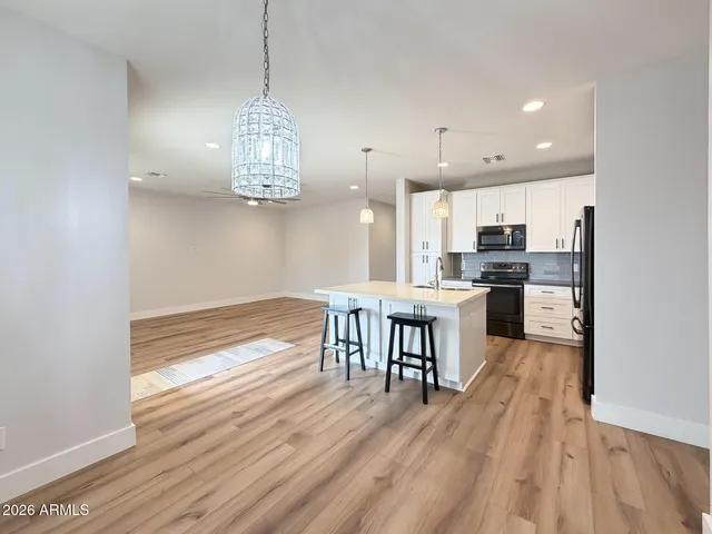 a kitchen with stainless steel appliances granite countertop a stove refrigerator and a wooden floor