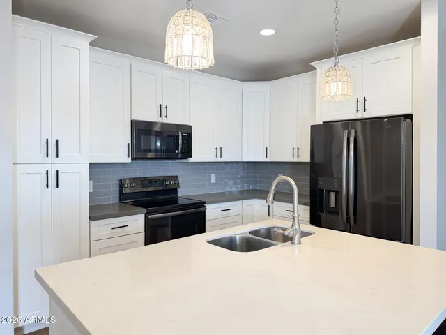 a kitchen with stainless steel appliances a refrigerator stove a sink and a microwave