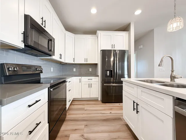 a kitchen with stainless steel appliances granite countertop a refrigerator sink and stove