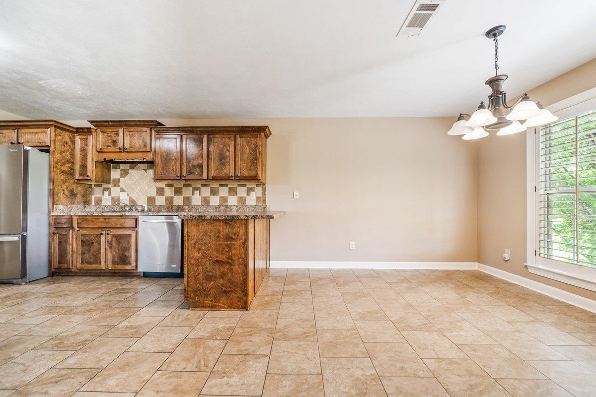 583 Rosemark Road Atoka, TN 38004 - Photo 7 of 25 a kitchen with stainless steel appliances granite countertop a stove a sink and a refrigerator