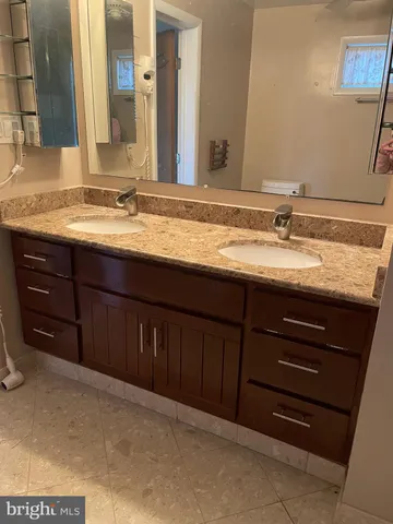a bathroom with a granite countertop sink and a mirror