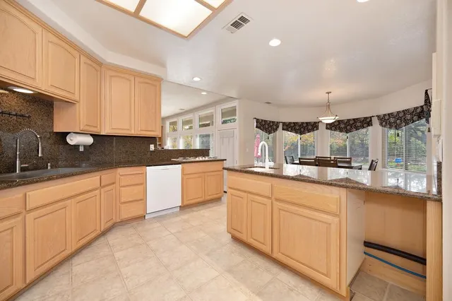 a kitchen with granite countertop white cabinets stainless steel appliances and sink