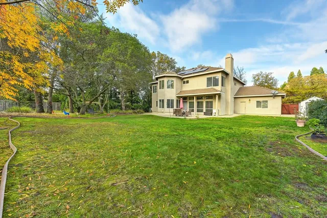 a backyard of a house with table and chairs