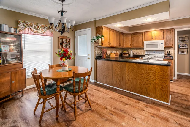 a kitchen with stainless steel appliances granite countertop a sink dishwasher stove and cabinets with wooden floor