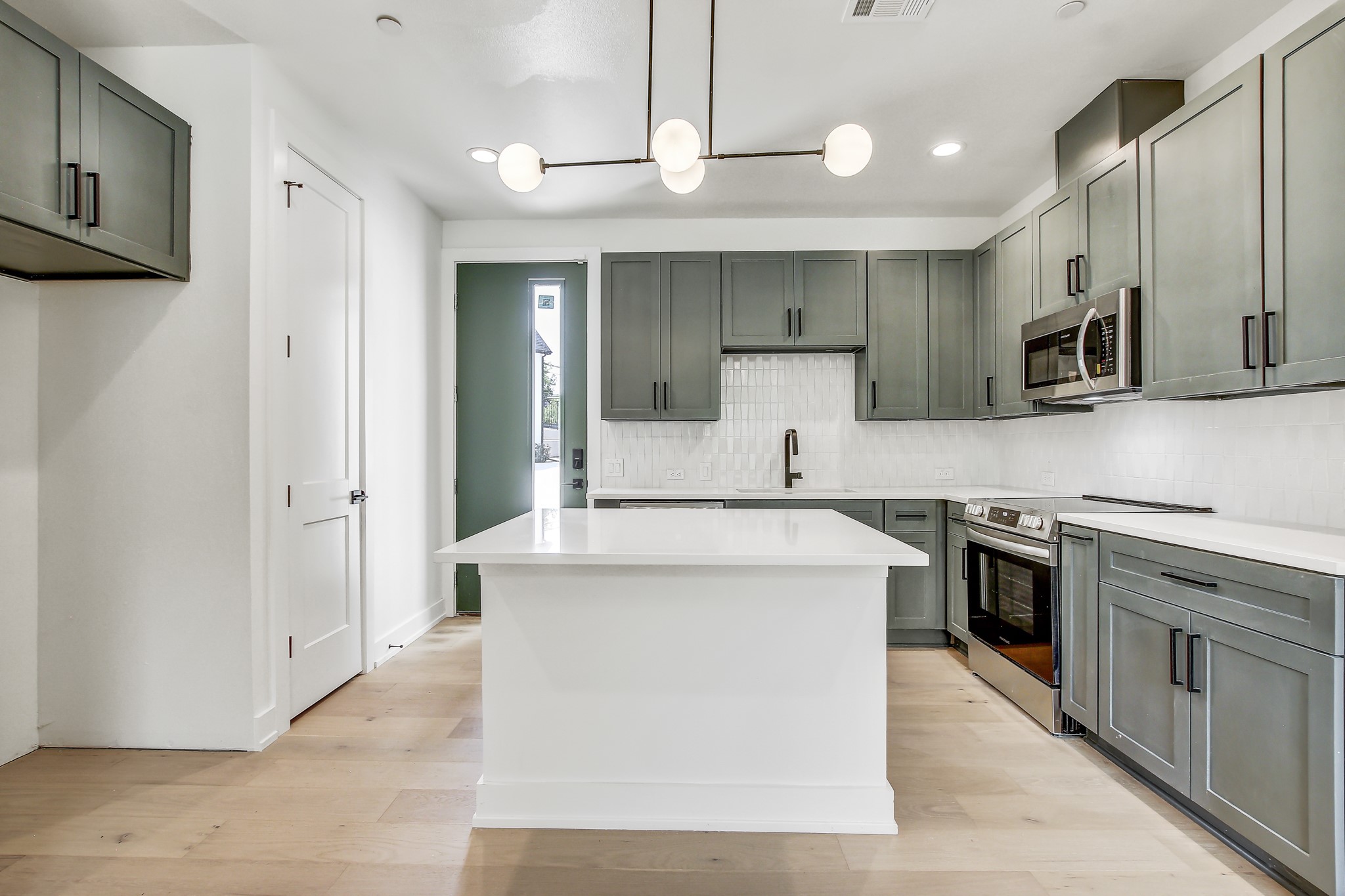 4127 East 12th Street, Unit 3 Austin, TX 78721 - Photo 10 of 29 Kitchen featuring appliances with stainless steel finishes, a sink, tasteful backsplash, light countertops, and recessed lighting