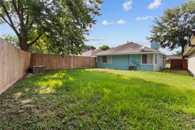 a view of a house with a yard and tree