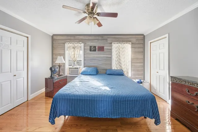 a bedroom with a bed and wooden floor