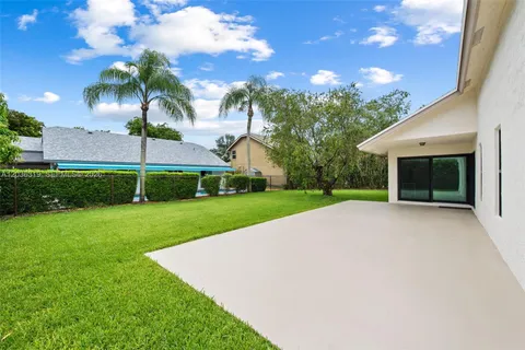 a view of a house with a yard and palm tree
