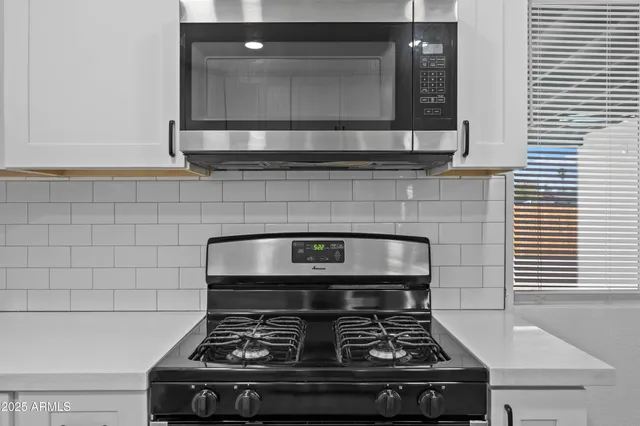 a stove top oven sitting inside of a kitchen