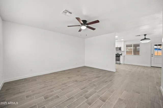 an empty room with closet and windows