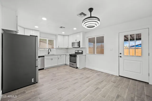 a kitchen with granite countertop stainless steel appliances a stove a refrigerator and cabinets