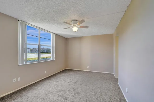 a view of room with a ceiling fan and window
