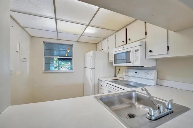 a kitchen with stainless steel appliances granite countertop a sink a stove and refrigerator