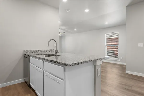 a kitchen with a sink cabinets and wooden floor
