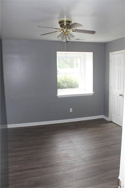 11203 Johnston Road Charlotte, NC 28226 - Photo 14 of 17 an empty room with wooden floor chandelier fan and windows