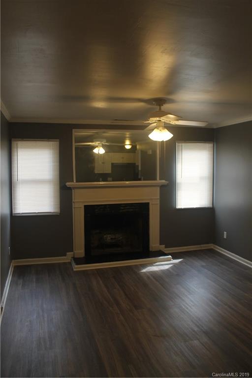 11203 Johnston Road Charlotte, NC 28226 - Photo 3 of 17 an empty room with wooden floor a fireplace and windows