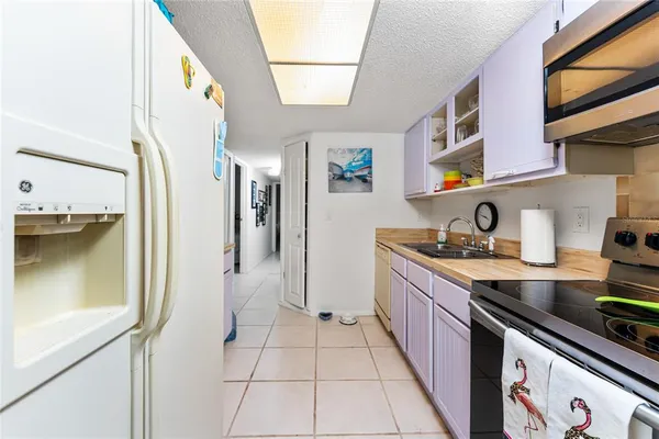 a kitchen with stainless steel appliances granite countertop a sink and a stove next to a white cabinet