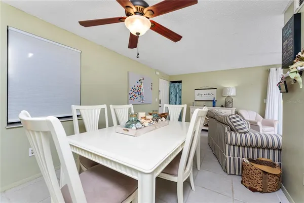 a view of a dining room with furniture and a chandelier fan
